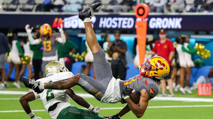 Receiver Phillip Bell lll of Mission Viejo (Calif.) gets upended by Juju Johnson of Long Beach Poly while making a touchdown reception in a game played at SoFi Stadium in Los Angeles. 