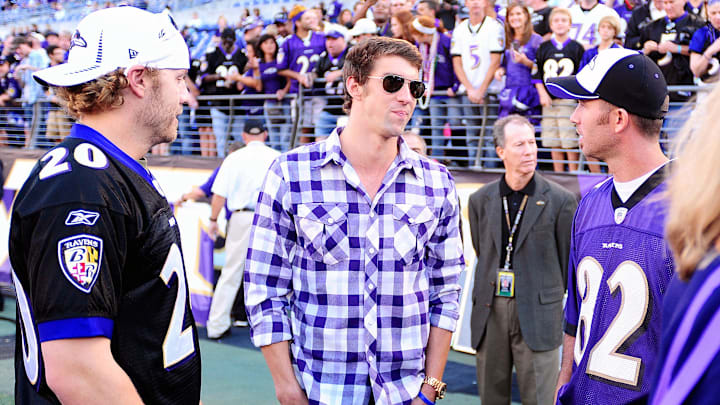 September 10, 2012; Baltimore, MD, USA; Olympic swimmer Michael Phelps (center) talks to Baltimore Orioles players Mark Reynolds (left) and J.J. Hardy (right) prior to the game between the Cincinnati Bengals and the Baltimore Ravens at M&T Bank Stadium. Mandatory Credit: Evan Habeeb-Imagn Images