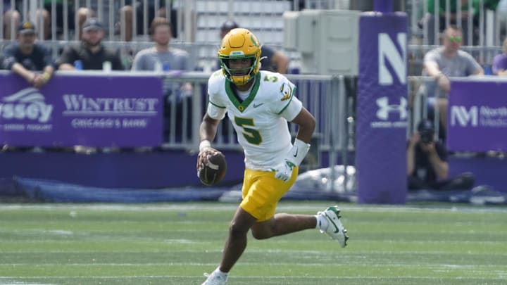 Sep 13, 2025; Evanston, Illinois, USA; Oregon Ducks quarterback Dante Moore (5) runs the ball past Northwestern Wildcats defensive lineman Anto Saka (4) during the first half at Northwestern Medicine Field at Martin Stadium. Mandatory Credit: David Banks-Imagn Images