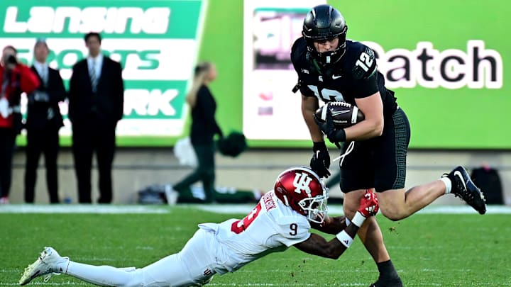 Nov 2, 2024; East Lansing, Michigan, USA; Michigan State Spartans tight end Jack Velling (12) evades Indiana Hoosiers defensive back Jamier Johnson (9) during the third quarter at Spartan Stadium. Mandatory Credit: Dale Young-Imagn Images Nov 2, 2024; East Lansing, Michigan, USA; Michigan State Spartans tight end Jack Velling (12) evades Indiana Hoosiers defensive back Jamier Johnson (9) during the third quarter at Spartan Stadium. Mandatory Credit: Dale Young-Imagn Images