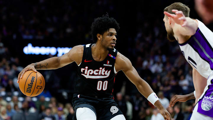Mar 27, 2025; Sacramento, California, USA; Portland Trail Blazers guard Scoot Henderson (00) dribbles against Sacramento Kings forward Domantas Sabonis (11) during the third quarter at Golden 1 Center. Mandatory Credit: Sergio Estrada-Imagn Images