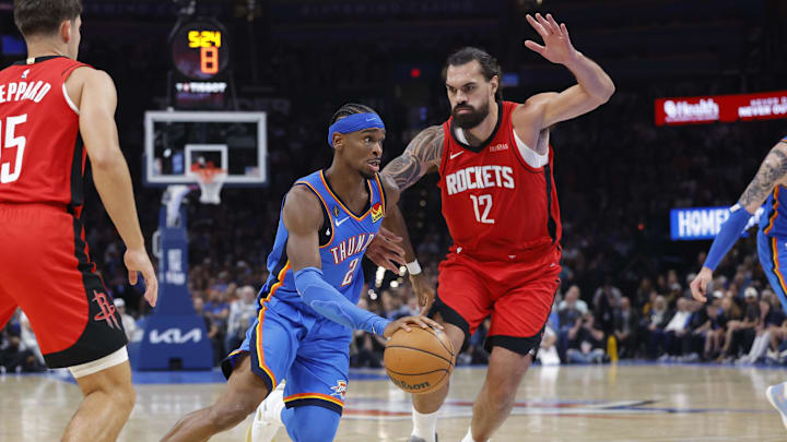 Oct 21, 2025; Oklahoma City, Oklahoma, USA; Oklahoma City Thunder guard Shai Gilgeous-Alexander (2) drives to the basket beside Houston Rockets center Steven Adams (12) during the first half at Paycom Center. Mandatory Credit: Alonzo Adams-Imagn Images