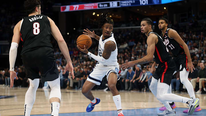 Memphis Grizzlies guard Ja Morant (12) drives to the basket between Portland Trail Blazers forward Deni Avdija (8) and forward Toumani Camara (33) during the second half at FedExForum. Mandatory Credit: Petre Thomas-Imagn Images