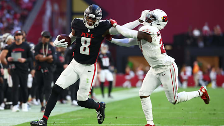 Dec 21, 2025; Glendale, Arizona, USA;  Atlanta Falcons tight end Kyle Pitts Sr. (8) runs after the catch and applies a stiff arm on Arizona Cardinals cornerback Akeem Davis (27) during the second half at State Farm Stadium. Mandatory Credit: Mark J. Rebilas-Imagn Images