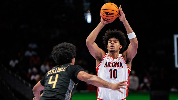 Mar 12, 2026; Kansas City, MO, USA; Arizona Wildcats forward Koa Peat (10) passes the ball over UCF Knights forward Jamichael Stillwell (4) during the first half at T-Mobile Center. Mandatory Credit: William Purnell-Imagn Images
