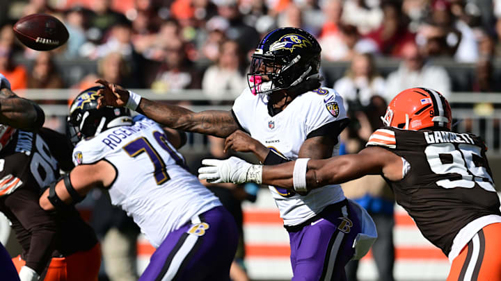 Oct 27, 2024; Cleveland, Ohio, USA; Baltimore Ravens quarterback Lamar Jackson (8) throws a pass as Cleveland Browns defensive end Myles Garrett (95) rushes during the first half at Huntington Bank Field. Mandatory Credit: Ken Blaze-Imagn Images