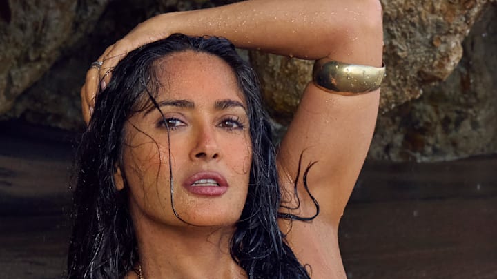 Salma Hayek Pinault was photographed by Ruven Afanador in Mexico. Swimsuit by Alameda Turquesa. Body chain by Baby Gold. Cuff by JUJU VERA.
