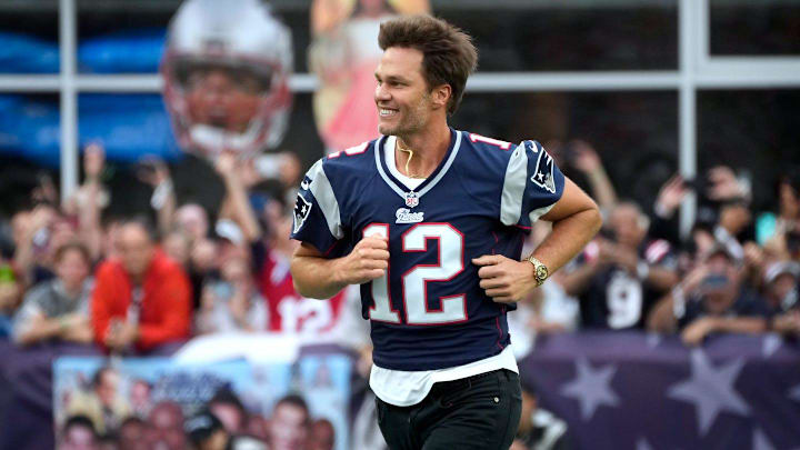 Former New England Patriots quarterback, Tom Brady, runs on to the field at Gillette Stadium on