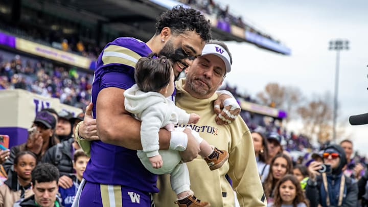 Quentin Moore and his young daughter Tatum are greeted by UW coach Jedd Fisch. Quentin Moore and his young daughter Tatum are greeted by UW coach Jedd Fisch.
