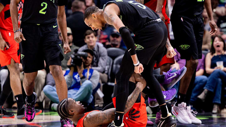 Mar 11, 2026; New Orleans, Louisiana, USA;  New Orleans Pelicans guard Dejounte Murray (5) leans over Toronto Raptors guard Jamal Shead (23) after making a three point basket during the second half at Smoothie King Center. Mandatory Credit: Stephen Lew-Imagn Images