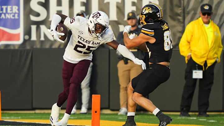Texas A&M Aggies safety Dalton Brooks (25) returns a fumble against Missouri Tigers tight end Jude James (89) during the first half at Faurot Field at Memorial Stadium. 