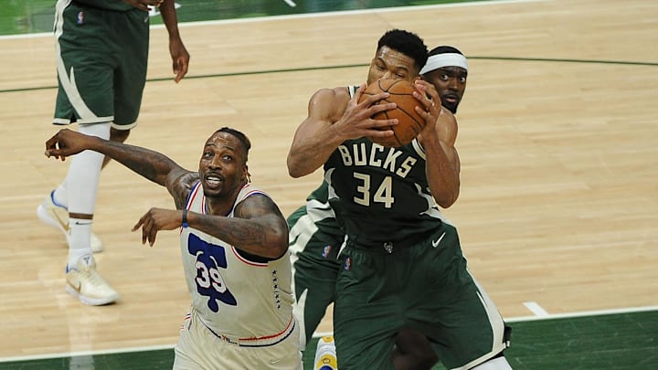 Apr 24, 2021; Milwaukee, Wisconsin, USA;  Milwaukee Bucks forward Giannis Antetokounmpo (34) grabs a rebound in front of Philadelphia 76ers center Dwight Howard (39) in the second quarter at Fiserv Forum. Mandatory Credit: Michael McLoone-Imagn Images