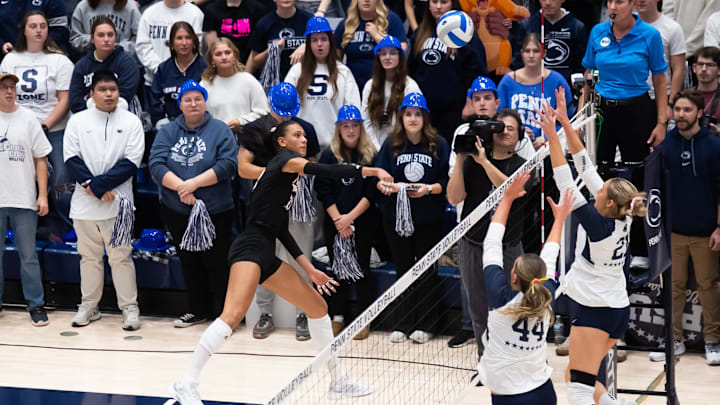 Nebraska's Harper Murray, left, hits the ball over the net during a Big Ten volleyball match 