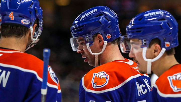 Bakersfield forward Greg McKegg (14) talks with defenseman Cam Dineen (4) and other teammates during a break in play during the third period of their game at Acrisure Arena in Palm Desert, Calif., Saturday, Dec. 16, 2023.