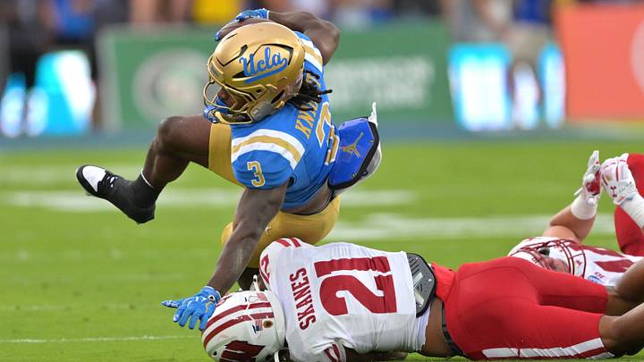 UCLA Bruins running back Wayne Knight (3) gets a first down before he is stopped by Wisconsin Badgers cornerback Cairo Skanes (21). UCLA Bruins running back Wayne Knight (3) gets a first down before he is stopped by Wisconsin Badgers cornerback Cairo Skanes (21).