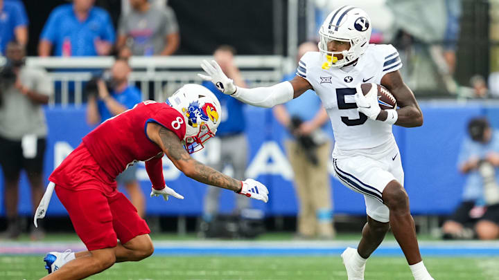 Sep 23, 2023; Lawrence, Kansas, USA; Brigham Young Cougars wide receiver Darius Lassiter (5) runs with the ball against Kansas Jayhawks cornerback Kwinton Lassiter (8) during the first half at David Booth Kansas Memorial Stadium. Mandatory Credit: Jay Biggerstaff-USA TODAY Sports