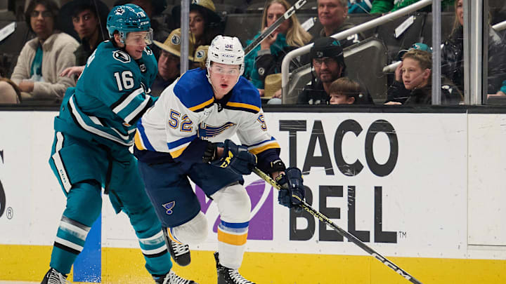 Apr 6, 2024; San Jose, California, USA; St. Louis Blues center Zach Dean (52) plays the puck against San Jose Sharks center Jack Studnicka (16) during the first period at SAP Center at San Jose. Mandatory Credit: Robert Edwards-Imagn Images