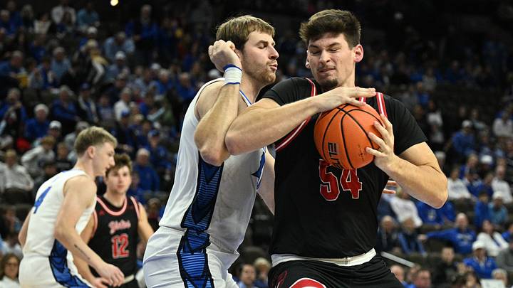 Nov 5, 2025; Omaha, Nebraska, USA;  South Dakota Coyotes center Cameron Fens (54) drives against Creighton Bluejays forward Isaac Traudt (41) during the first half at CHI Health Center Omaha. Mandatory Credit: Steven Branscombe-Imagn Images