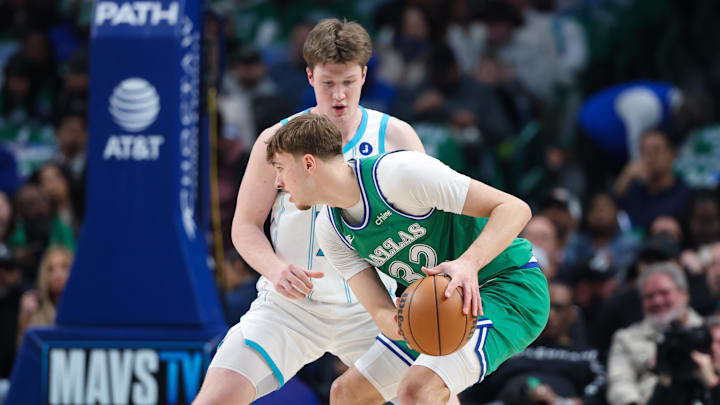 Dallas Mavericks forward Cooper Flagg (32) controls the ball as Charlotte Hornets guard Kon Knueppel (7) defends Dallas Mavericks forward Cooper Flagg (32) controls the ball as Charlotte Hornets guard Kon Knueppel (7) defends