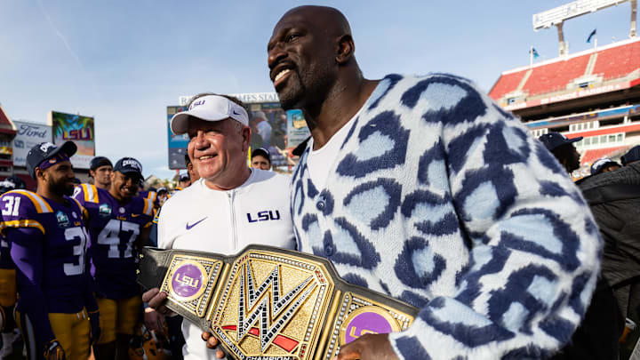 Jan 1, 2024; Tampa, FL, USA; LSU Tigers head coach Brian Kelly and WWE superstar Titus O   Neil hold