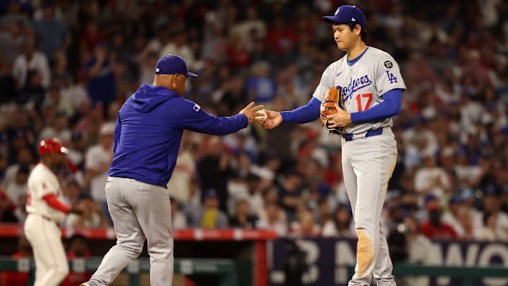 Aug 13, 2025; Anaheim, California, USA; Los Angeles Dodgers two-way player Shohei Ohtani (17) hands the ball to manager Dave Roberts (30, left) during the fifth inning against the Los Angeles Angels at Angel Stadium. Mandatory Credit: Kiyoshi Mio-Imagn Images Aug 13, 2025; Anaheim, California, USA; Los Angeles Dodgers two-way player Shohei Ohtani (17) hands the ball to manager Dave Roberts (30, left) during the fifth inning against the Los Angeles Angels at Angel Stadium. Mandatory Credit: Kiyoshi Mio-Imagn Images