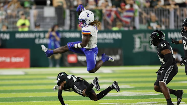 Boise State Broncos running back Ashton Jeanty (2) leaps over Hawaii Rainbow Warriors defensive back Deliyon Freeman (26).