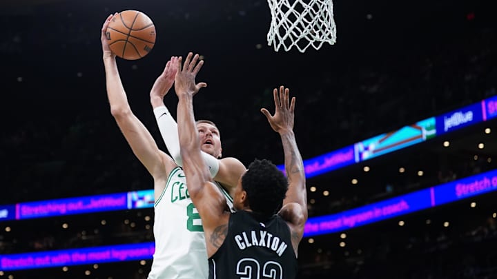 Feb 14, 2024; Boston, Massachusetts, USA: Boston Celtics center Kristaps Porzingis (8) shoots against Brooklyn Nets center Nic Claxton (33) in the first half at TD Garden. Mandatory Credit: David Butler II-Imagn Images