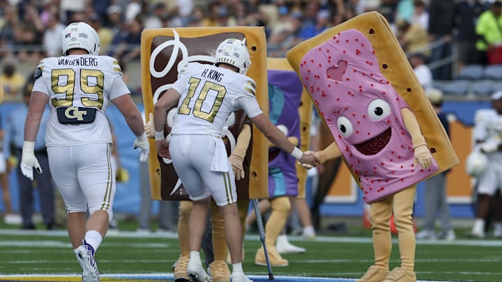 Dec 27, 2025; Orlando, FL, USA; Georgia Tech Yellow Jackets quarterback Haynes King (10) greats the Pop-Tarts mascots before the Pop-Tarts Bowl against the BYU Cougars at Camping World Stadium. Mandatory Credit: Nathan Ray Seebeck-Imagn Images