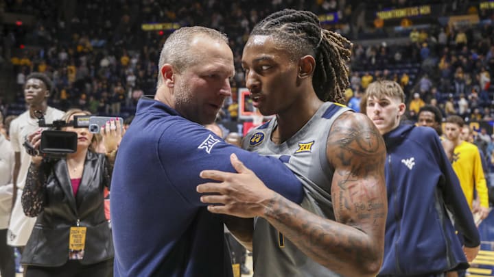 Mar 8, 2025; Morgantown, West Virginia, USA; West Virginia Mountaineers head coach Darian DeVries and guard Javon Small (7) celebrate after defeating the UCF Knights at WVU Coliseum. Mandatory Credit: Ben Queen-Imagn Images