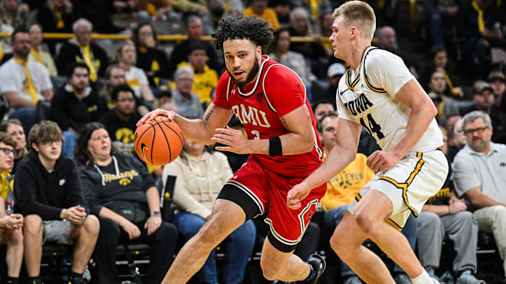 Robert Morris Colonials guard Ryan Prather Jr. dribbling by Iowa Hawkeyes guard Bennett Stirtz.
