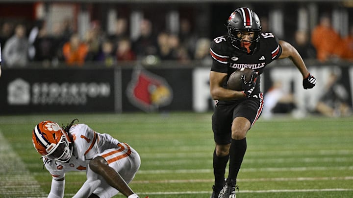 Nov 14, 2025; Louisville, Kentucky, USA;  Louisville Cardinals wide receiver Antonio Meeks (15) runs the ball against Clemson Tigers cornerback Branden Strozier (1) during the second half at L&N Federal Credit Union Stadium. Clemson defeated Louisville 20-19. Mandatory Credit: Jamie Rhodes-Imagn Images