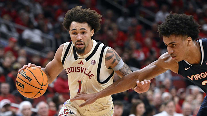 Jan 18, 2025; Louisville, Kentucky, USA;  Louisville Cardinals guard J'Vonne Hadley (1) drives to the basket against Virginia Cavaliers forward Anthony Robinson (21) during the second half at KFC Yum! Center. Louisville defeated Virginia 81-67. 