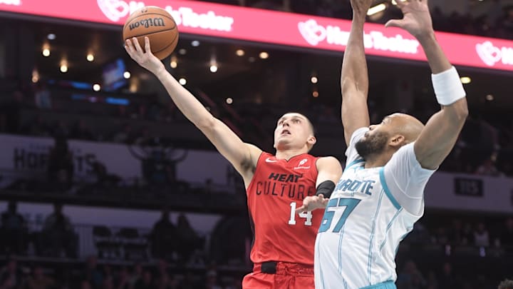 Nov 27, 2024; Charlotte, North Carolina, USA;  Miami Heat guard Tyler Herro (14) shoots the ball against Charlotte Hornets center Taj Gibson (67) during the first half at the Spectrum Center. Mandatory Credit: Sam Sharpe-Imagn Images