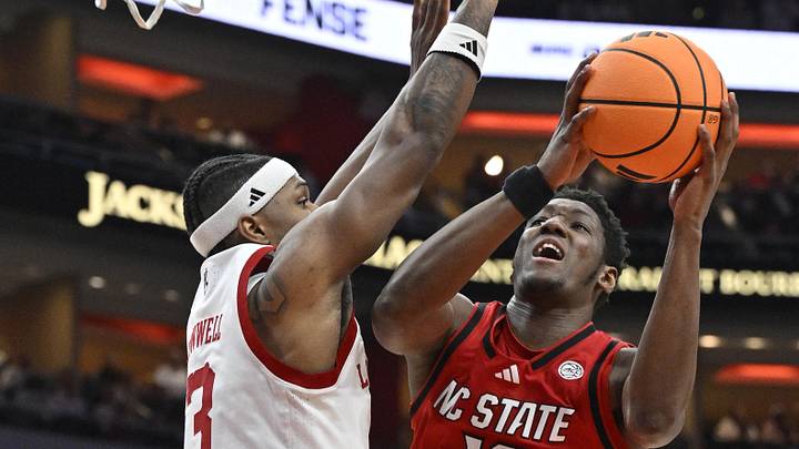 Feb 9, 2026; Louisville, Kentucky, USA;  NC State Wolfpack forward Musa Sagnia (13) shoots against Louisville Cardinals guard Ryan Conwell (3) during the first half at KFC Yum! Center. Louisville defeated N.C. State 118-77. Mandatory Credit: Jamie Rhodes-Imagn Images