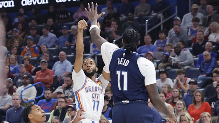 Feb 24, 2025; Oklahoma City, Oklahoma, USA; Oklahoma City Thunder guard Isaiah Joe (11) shoots a three point basket beside Minnesota Timberwolves guard Rob Dillingham (4) during the second quarter at Paycom Center. Mandatory Credit: Alonzo Adams-Imagn Images