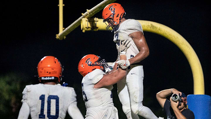 Benjamin offensive lineman Chase Malamala hoists wide receiver Amaree Williams in the air after a towchdown catch during their football game on October 20, 2023 in West Palm Beach, Florida.