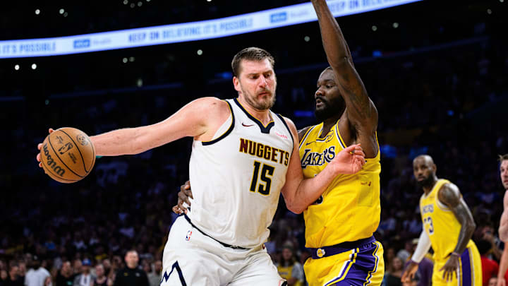 Mar 14, 2026; Los Angeles, California, USA; Denver Nuggets center Nikola Jokic (15) drives the ball while under pressure from Los Angeles Lakers center Deandre Ayton (5) during overtime at Crypto.com Arena. Mandatory Credit: William Liang-Imagn Images