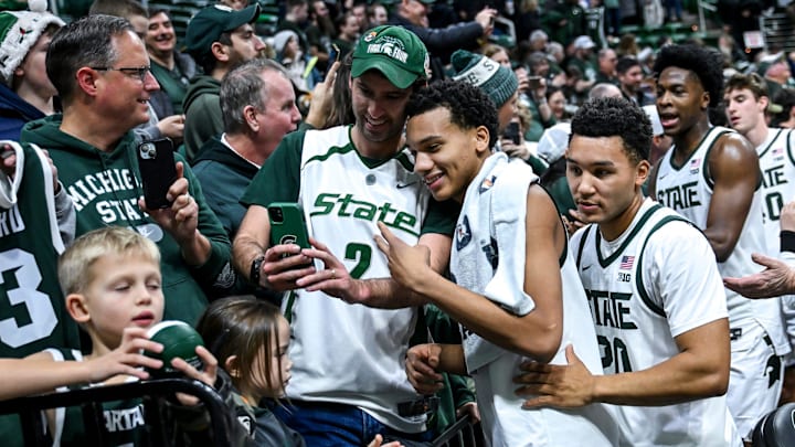 Michigan State's Divine Ugochukwu, right, poses with fans after the Spartans win over Cornell during the second half on Monday, Dec. 29, 2025, at the Breslin Center in East Lansing.