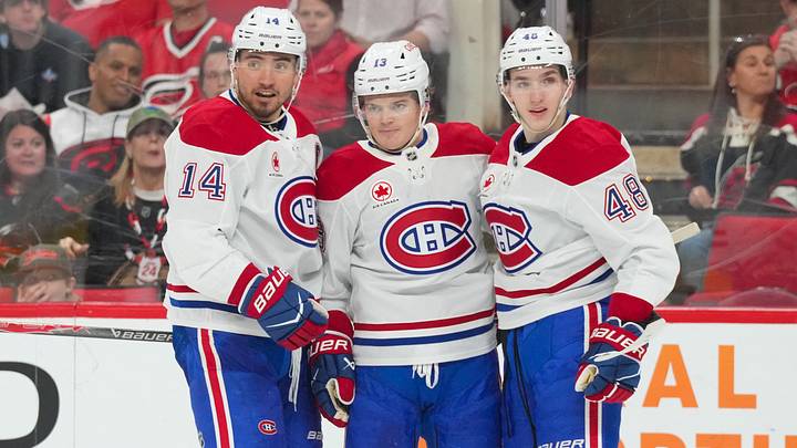 Montreal Canadiens center Nick Suzuki (14) is congratulated by defenseman Lane Hutson (48) and right wing Cole Caufield (13) after his goal against the Carolina Hurricanes during the second period at Lenovo Center. Mandatory Credit: James Guillory-Imagn Images