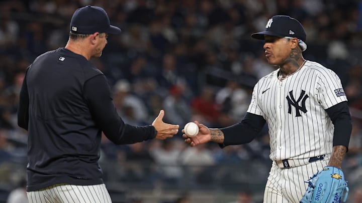 Sep 10, 2024; Bronx, New York, USA; New York Yankees starting pitcher Marcus Stroman (0) hands the ball to manager Aaron Boone (17) after being relieved sixth inning against the Kansas City Royals at Yankee Stadium. Mandatory Credit: Vincent Carchietta-Imagn Images