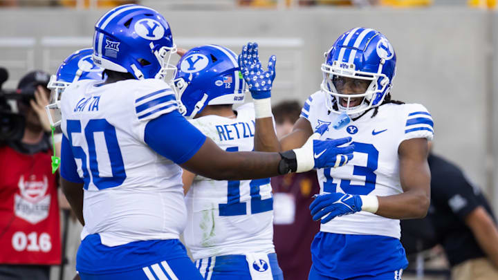 Nov 23, 2024; Tempe, Arizona, USA; Brigham Young Cougars wide receiver Jojo Phillips (13) celebrates a touchdown with offensive lineman Isaiah Jatta (50) against the Arizona State Sun Devils at Mountain America Stadium. Mandatory Credit: Mark J. Rebilas-Imagn Images