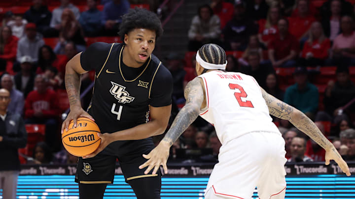 Feb 21, 2026; Salt Lake City, Utah, USA; UCF Knights forward Jamichael Stillwell (4) looks for the play as Utah Utes guard Terrence Brown (2) defends during the first half at Jon M. Huntsman Center. Mandatory Credit: Rob Gray-Imagn Images