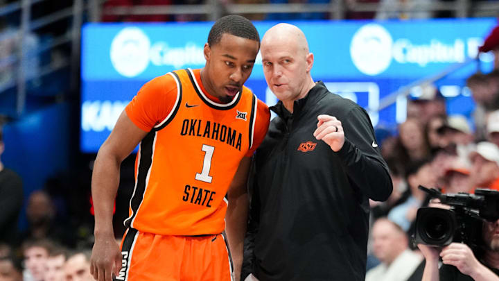 Feb 22, 2025; Lawrence, Kansas, USA; Oklahoma State Cowboys guard Bryce Thompson (1) talks with head coach Steve Lutz against the Kansas Jayhawks during the first half at Allen Fieldhouse. Mandatory Credit: Denny Medley-Imagn Images