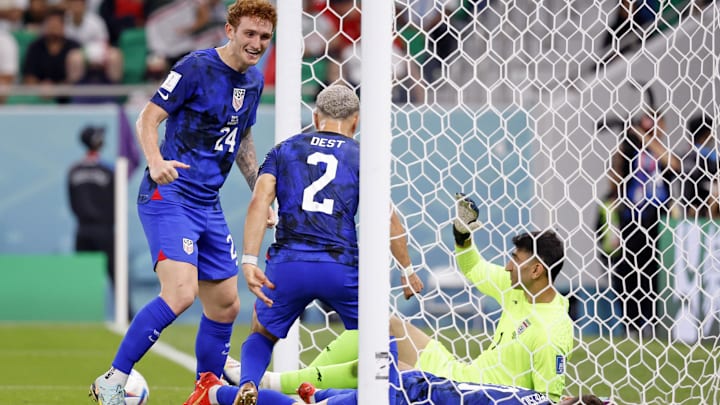 Josh Sargent and Sergino Dest celebrate the USMNT's goal against Iran during the 2022 World Cup.