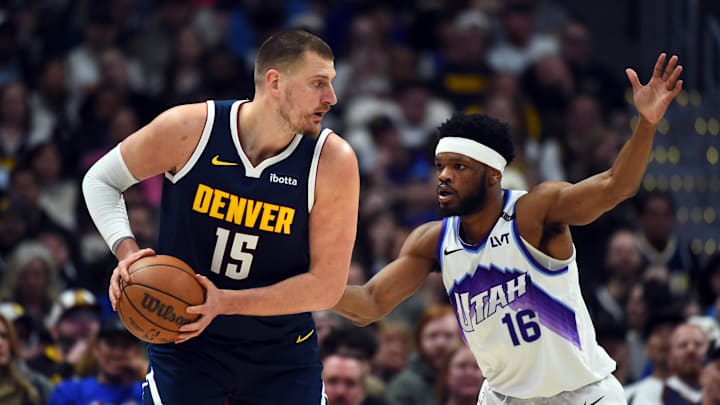 Mar 27, 2026; Denver, Colorado, USA; Denver Nuggets center Nikola Jokic (15) looks to pass the ball as he is defended by Utah Jazz guard Elijah Harkless (16) during the first half at Ball Arena. Mandatory Credit: Christopher Hanewinckel-Imagn Images