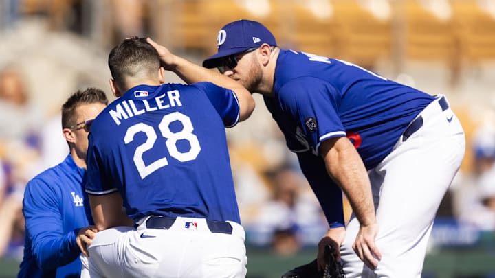 Los Angeles Dodgers pitcher Bobby Miller (28) talks to Max Muncy as he is tended to by a trainer after being hit in the head with a line drive against the Chicago Cubs during a spring training game at Camelback Ranch-Glendale.  