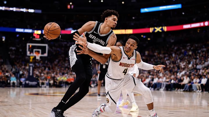 Jan 3, 2025; Denver, Colorado, USA; San Antonio Spurs center Victor Wembanyama (1) controls the ball under pressure from Denver Nuggets guard Russell Westbrook (4) in the first quarter at Ball Arena. Mandatory Credit: Isaiah J. Downing-Imagn Images
