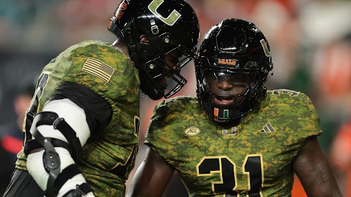 Oct 25, 2025; Miami Gardens, Florida, USA; Miami Hurricanes linebacker Wesley Bissainthe (31) celebrates with offensive lineman Markel Bell (70) after intercepting a pass against the Stanford Cardinal during the third quarter at Hard Rock Stadium. Mandatory Credit: Sam Navarro-Imagn Images