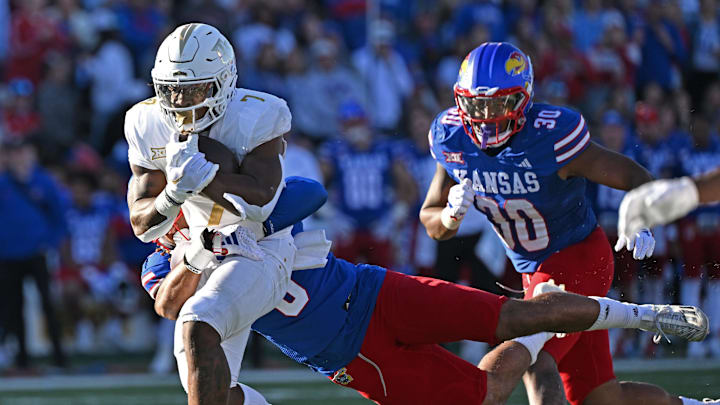 Oct 7, 2023; Lawrence, Kansas, USA; UCF Knights running back RJ Harvey (7) runs up field against Kansas Jayhawks linebacker Taiwan Berryhill Jr. (6) during the second half at David Booth Kansas Memorial Stadium. Mandatory Credit: Peter Aiken-Imagn Images