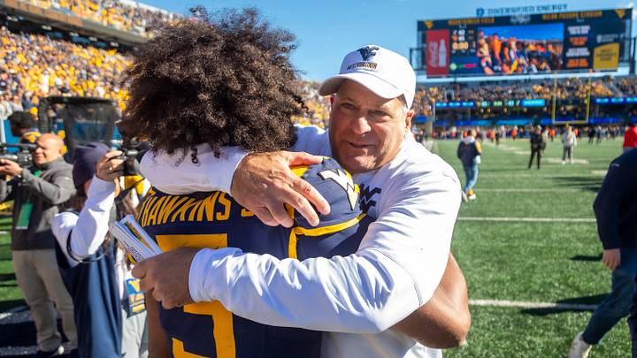 Oct 17, 2026; Morgantown, West Virginia, USA; West Virginia Mountaineers head coach Rich Rodriguez celebrates with quarterback Michael Hawkins Jr. (3) after defeating the Cincinnati Bearcats at Milan Puskar Stadium. Mandatory Credit: Ben Queen-Imagn Images Oct 17, 2026; Morgantown, West Virginia, USA; West Virginia Mountaineers head coach Rich Rodriguez celebrates with quarterback Michael Hawkins Jr. (3) after defeating the Cincinnati Bearcats at Milan Puskar Stadium. Mandatory Credit: Ben Queen-Imagn Images